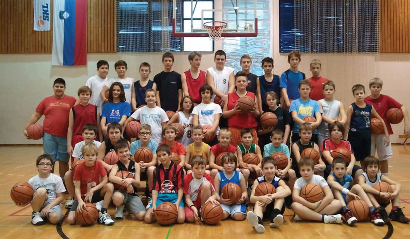 Množična fotografija mlajših selekcij KK Jesenice z žogami v telovadnici